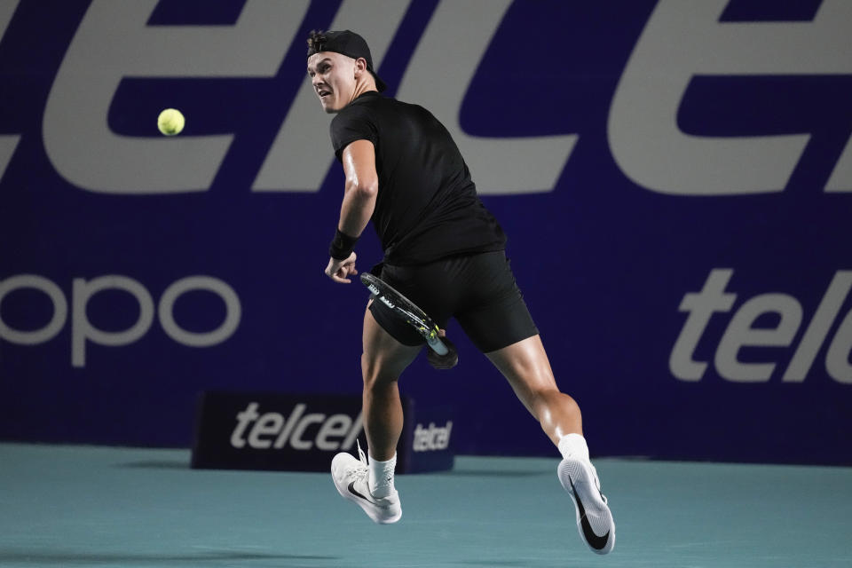 Holger Rune, of Denmark, hits a tweener during a semifinal against Casper Ruud, of Norway, at the Mexican Open tennis tournament in Acapulco, Mexico, Friday, March 1, 2024. (AP Photo/Eduardo Verdugo)
