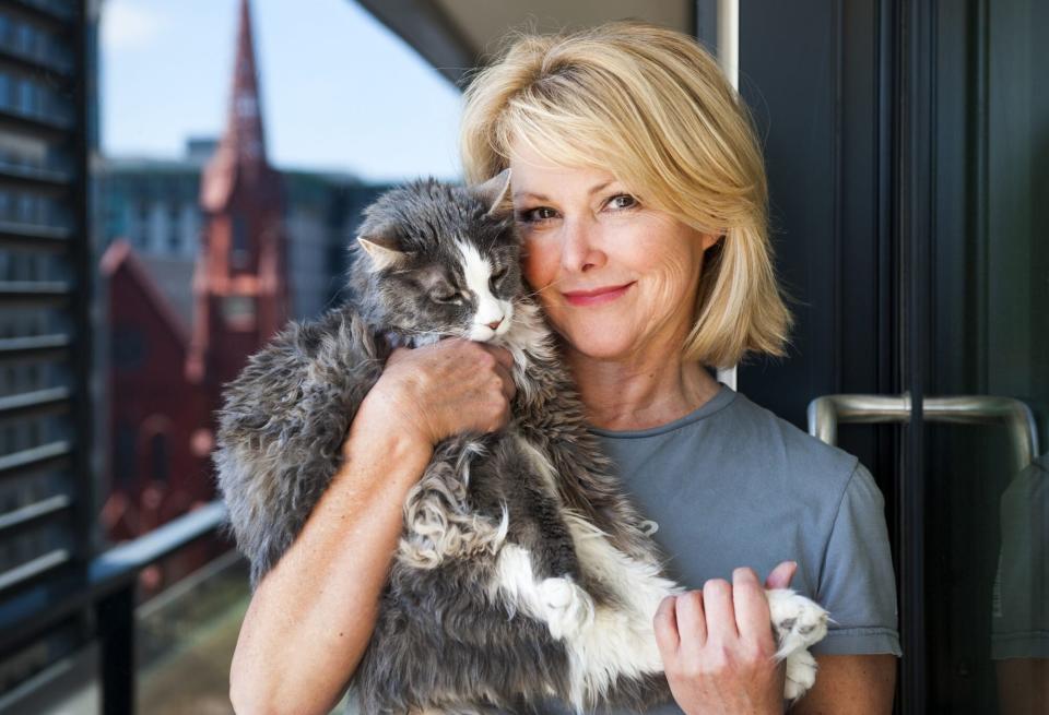 WASHINGTON, DC - APRIL 24: Wendy Rieger, with her 16-year-old cat Rudy, enjoy the balcony where the Calvary Baptist Church is reflected in the partitions between condos April 24, 2014 in Washington, DC. Rieger, an anchor at NBC-owned station WRC (Channel 4) splits her time between a condo in the CityCenter and a home in Annapolis. (Photo by Katherine Frey/The Washington Post via Getty Images)