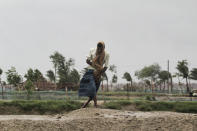 A man walks against the force of the wind ahead of Cyclone Amphan landfall, at Bhadrak district, in the eastern Indian state of Orissa, Wednesday, May 20, 2020. A strong cyclone blew heavy rains and strong winds into coastal India and Bangladesh on Wednesday after more than 2.6 million people were moved to shelters in a frantic evacuation made more challenging by coronavirus. (AP Photo)