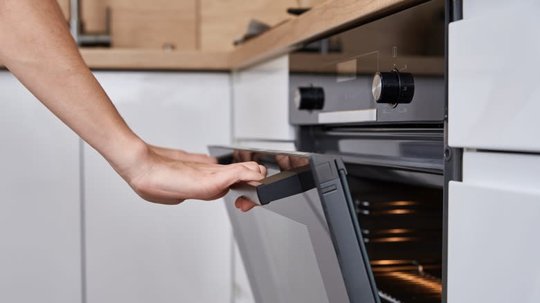 Opening kitchen oven with hand