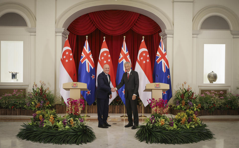 In this photo released by Singapore's Ministry of Communications and Information, New Zealand Prime Minister Luxon, left, shakes hands with Singapore's Prime Minister Lee Hsien Loong at the Istana, Monday, April 15, 2024. (Terence Tan/Ministry of Communications and Information via AP)