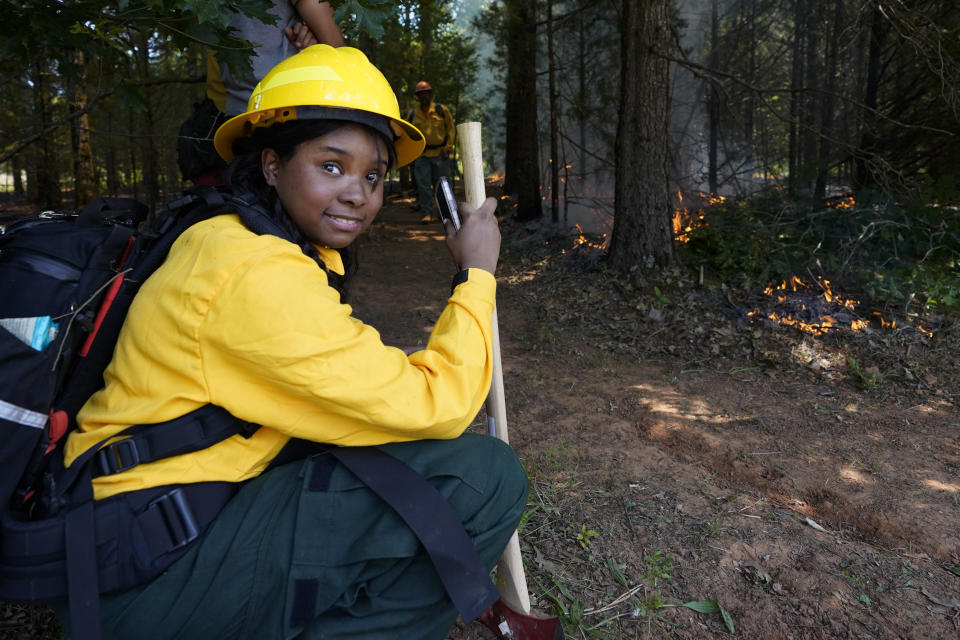 Kayla Woods rests during a wildland firefighter training Friday, June 9, 2023, in Hazel Green, Ala. A partnership between the U.S. Forest Service and four historically Black colleges and universities is opening the eyes of students of color who had never pictured themselves as fighting forest fires. (AP Photo/George Walker IV)