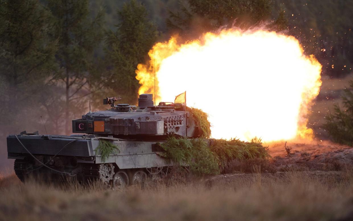 A Leopard 2 main battle tank of the German armed forces Bundeswehr shoots during a visit by the German Chancellor of the troops during a training exercise at the military ground in Ostenholz, northern Germany, on October 17, 2022. - RONNY HARTMANN/AFP