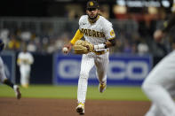 San Diego Padres shortstop Fernando Tatis Jr. gets ready to toss the ball to first for the out on Milwaukee Brewers' Travis Shaw during the sixth inning of a baseball game, Monday, April 19, 2021, in San Diego. (AP Photo/Gregory Bull)