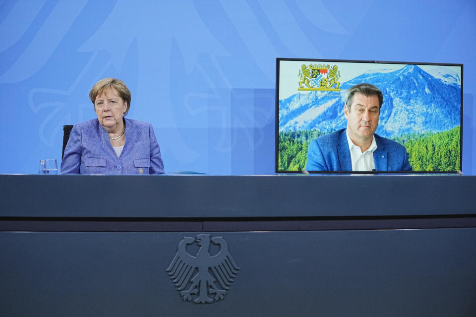 Bundeskanzlerin Angela Merkel (CDU) sitzt neben dem zugeschalteten Markus Söder (CSU), Ministerpräsident von Bayern bei der Pressekonferenz nach der Ministerpräsidentenkonferenz.