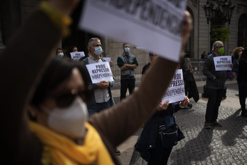 Demonstrators holding placards reading in Catalan "stop repression, Independence" take part in a protest to condemn a police raid on Catalan separatists in Barcelona, Spain, Wednesday, Oct. 28, 2020. Spanish officials say that police have arrested 21 individuals with links to the Catalan separatist movement on suspicion of corruption and promoting public disorder. (AP Photo/Emilio Morenatti)