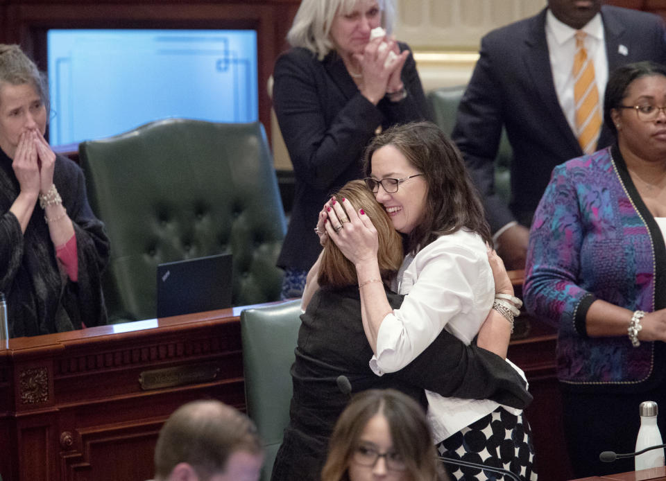 Illinois state Rep. Kelly Cassidy, center right, D-Chicago, embraces Rep. Sara Feigenholtz, D-Chicago, after the Reproductive Health Act passed the Illinois House 64-50 Tuesday, May 28, 2019., in Springfield, Ill. The legislation rewrote Illinois' current abortion law to make it less restrictive. (Ted Schurter/The State Journal-Register via AP)