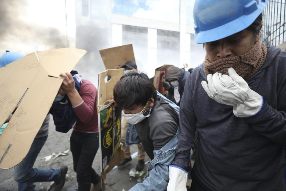 Anti-government demonstrators walk away from tear gas during clashes with police in Quito, Ecuador, Saturday, Oct. 12, 2019. Protests, which began when President Lenin Moreno's decision to cut subsidies led to a sharp increase in fuel prices, have persisted for days. (AP Photo/Fernando Vergara)