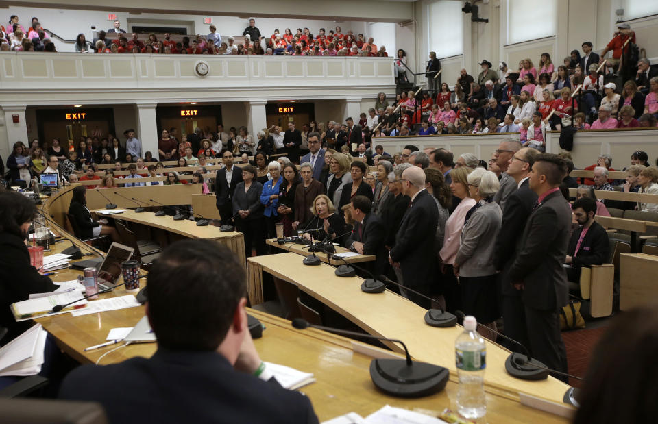 Mass. state Rep. Patricia Haddad, D-Bristol, seated center, raises her hand while testifying in favor of a proposed bill, called the "Roe Act" by supporters, during a public hearing at the Statehouse, Monday, June 17, 2019, in Boston. Proponents on both sides of the abortion issue testified during the public hearing on a bill that would let women obtain an abortion after 24 weeks of pregnancy in cases of "fatal fetal anomalies." Haddad was flanked by lawmakers also supporting the bill. (AP Photo/Steven Senne)