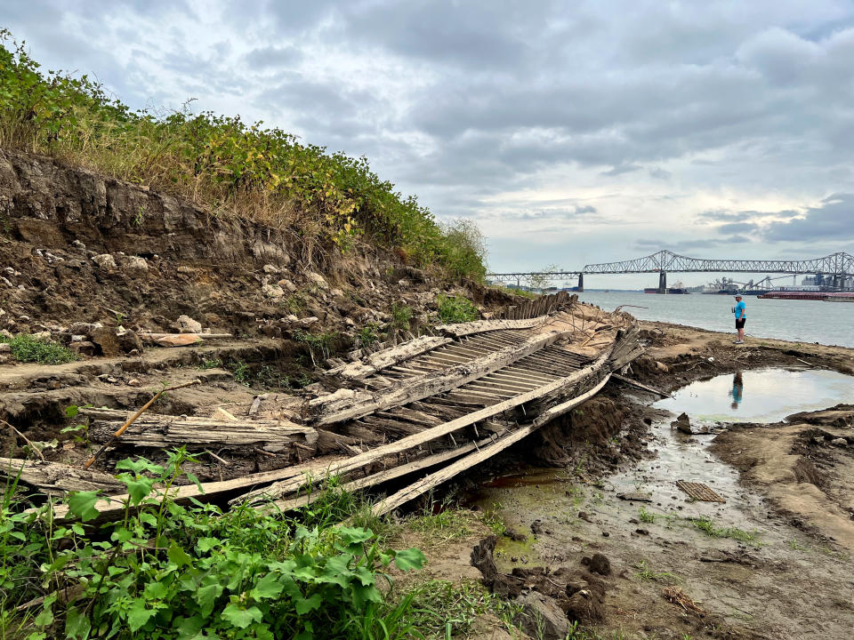 FILE - A man walking along the Mississippi River in Baton Rouge, La., stops to look at a shipwreck revealed by the low water level, Oct. 17, 2022. The ship, which archaeologists believe to be a ferry that sunk in the late 1800s to early 1900s, was spotted by a Baton Rouge resident walking along the shore earlier this month. (AP Photo/Sara Cline, File)