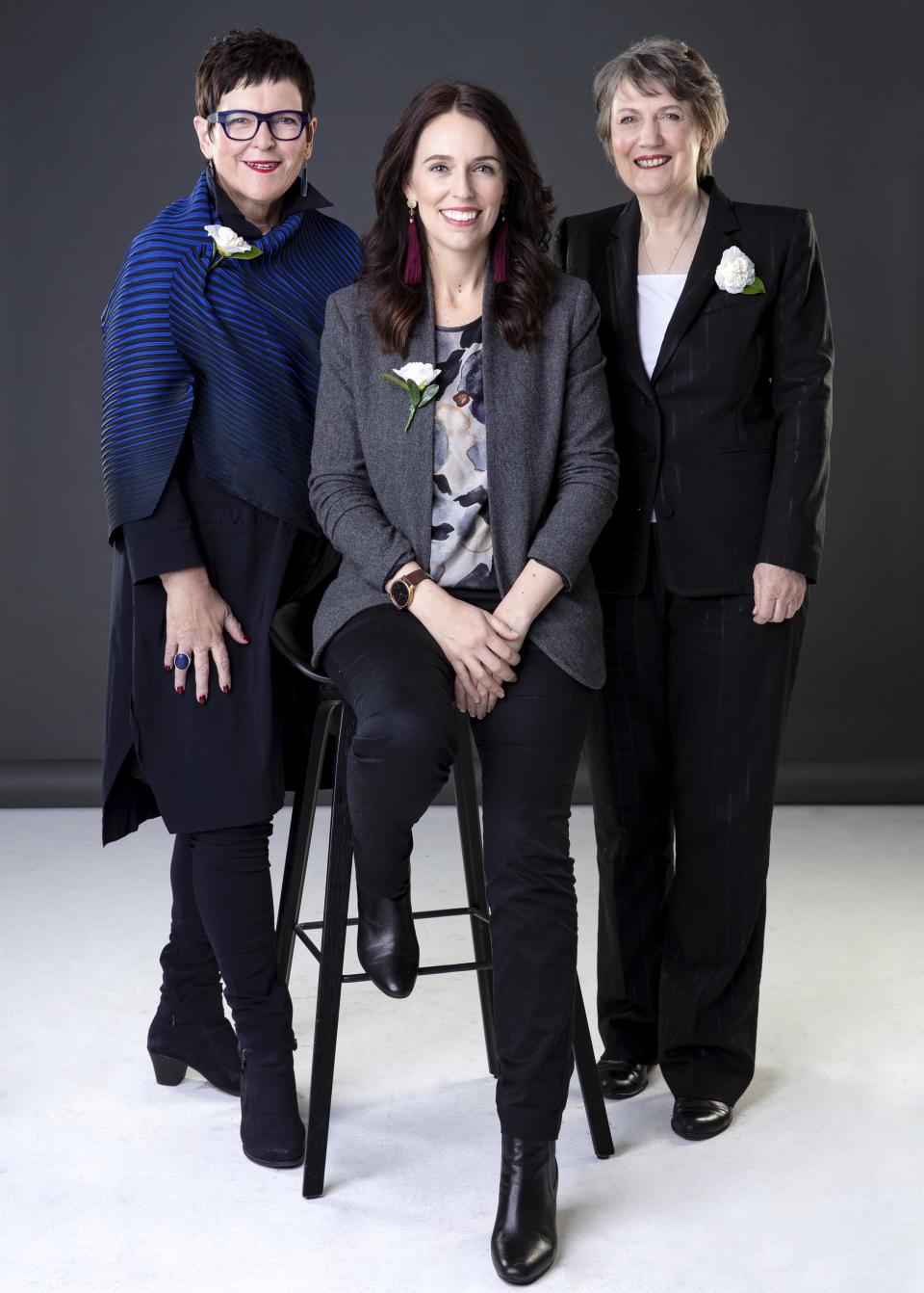 In this Sept. 1, 2018 photo, New Zealand Prime Minister Jacinda Ardern, center, sits for a portrait with former prime minister's Jenny Shipley, left, and Helen Clark, right, in Auckland, New Zealand. New Zealand became the first nation in the world to allow women to vote 125 years ago, and hundreds of people celebrated the anniversary by turning out to gatherings and speeches with some wearing period costumes or the white camellia flowers — a symbol of the movement. (Babiche Martens/New Zealand Herald via AP)