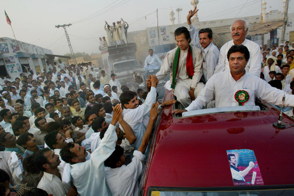 Cricket captain turned politician Imran Khan shakes hands with supporters during a rally in October 2002 in Shadi Khal, Pakistan.<span class="copyright">Paula Bronstein—Getty Images</span>