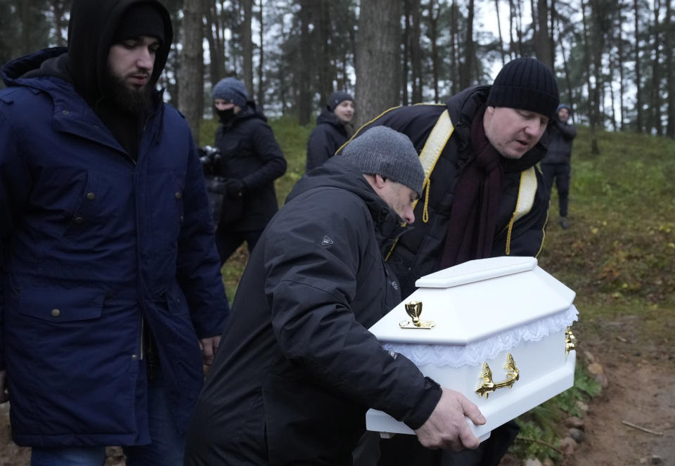 A Polish imam, right, and two other members of a Muslim community bury the tiny white casket of an unborn Iraqi boy, in Bohoniki, Poland, on Tuesday Nov. 23, 2021. The child is the latest life claimed as thousands of migrants from the Middle East have sought to enter the European Union but found their path cut off by a military build-up and fast approaching winter in the forests of Poland and Belarus. (AP Photo/Czarek Sokolowski)