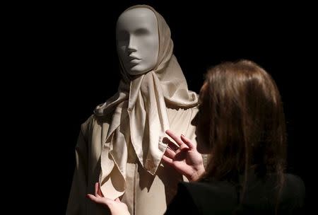 An employee arranges a scarf and coat, part of the collection of former British prime minister Margaret Thatcher during an auction preview at Christie's in London, Britain, December 11, 2015. REUTERS/Peter Nicholls