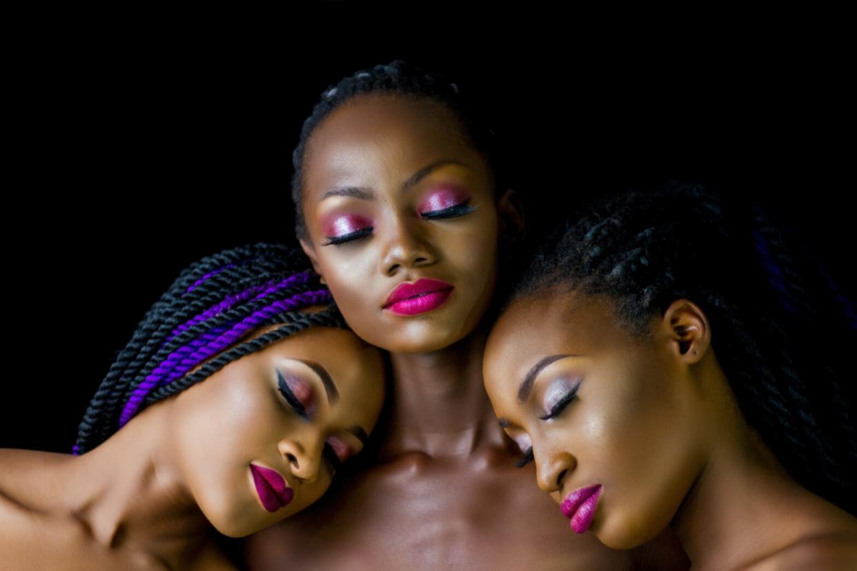 three black women with bold makeup on