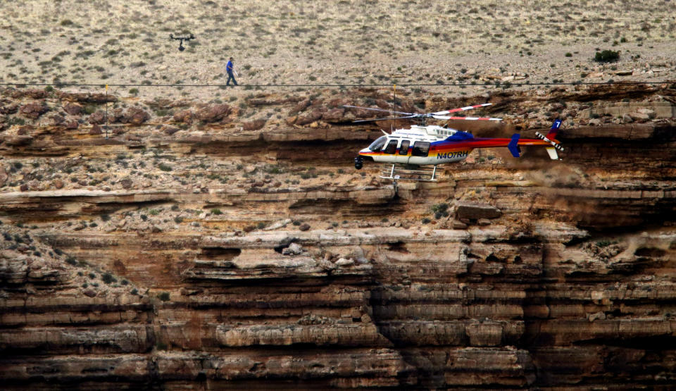 FILE - In this June 23, 2013, file photo, daredevil Nik Wallenda crosses a tightrope 1,500 feet above the Little Colorado River Gorge, Ariz., on the Navajo Nation outside the boundaries of Grand Canyon National Park. When actor Will Smith turns 50 on Tuesday, he will jump head-first into the big milestone. The “Fresh Prince” plans to bungee jump from a helicopter over a gorge just outside Grand Canyon National Park. His birthday activity is the latest in a vast history of outrageous stunts staged in and around one of the world’s seven natural wonders. (AP Photo/Rick Bowmer, File)