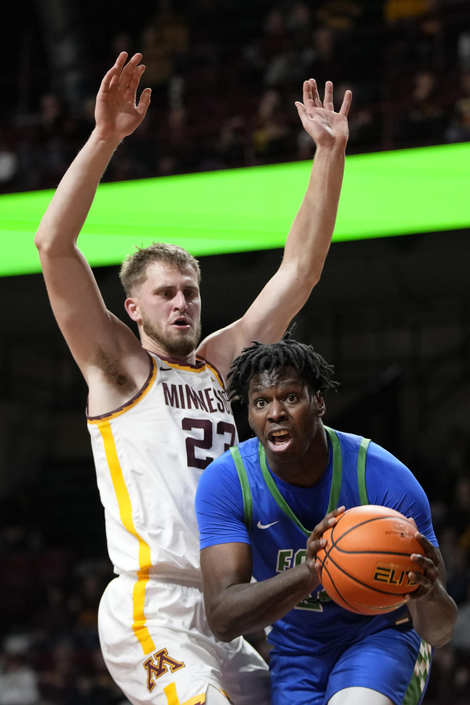 Florida Gulf Coast forward Josiah Shackleford handles the basketball as Minnesota forward Parker Fox (23) defends during the second half of an NCAA college basketball game Saturday, Dec. 9, 2023, in Minneapolis. (AP Photo/Abbie Parr)