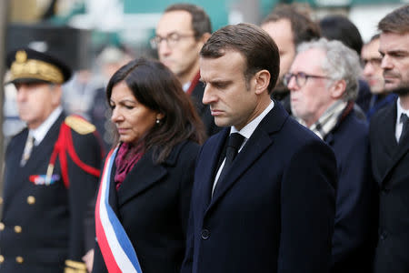 French President Emmanuel Macron (R) and Mayor of Paris Anne Hidalgo (L) stand in front of the 'Comptoir Voltaire' bar during a ceremony marking the second anniversary of the Paris attacks of November 2015 in which 130 people were killed, in Paris, France, November 13, 2017. REUTERS/Etienne Laurent/Pool