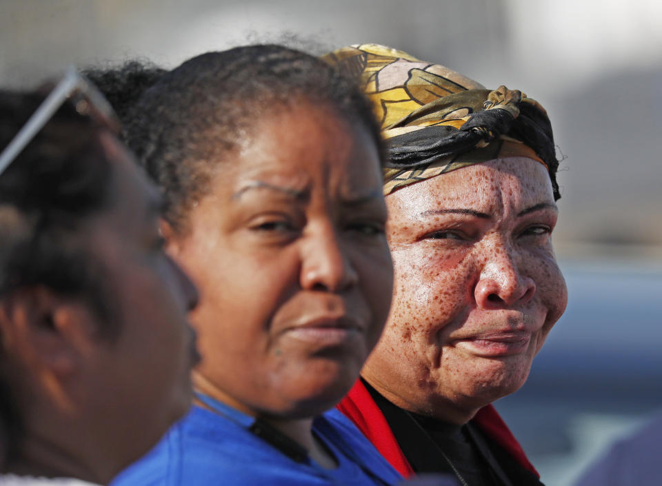 Friends, coworkers and family talk among themselves as they watch as U.S. immigration officials raid the Koch Foods Inc., plant in Morton, Miss., Wednesday, Aug. 7, 2019. U.S. immigration officials raided several Mississippi food processing plants on Wednesday and signaled that the early-morning strikes were part of a large-scale operation targeting owners as well as employees. (AP Photo/Rogelio V. Solis)