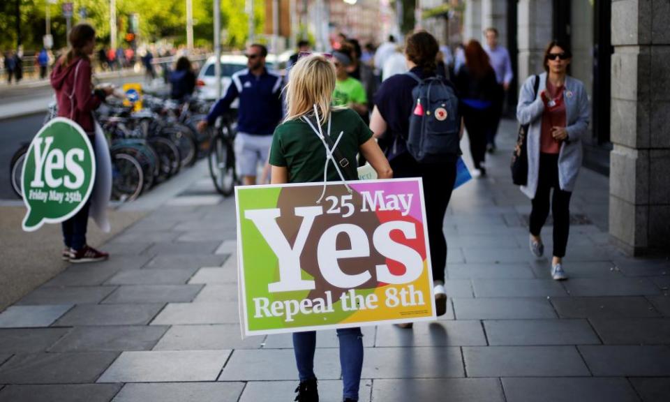 A woman carries a placard urging voters to back the liberalisation of abortion laws in Ireland.