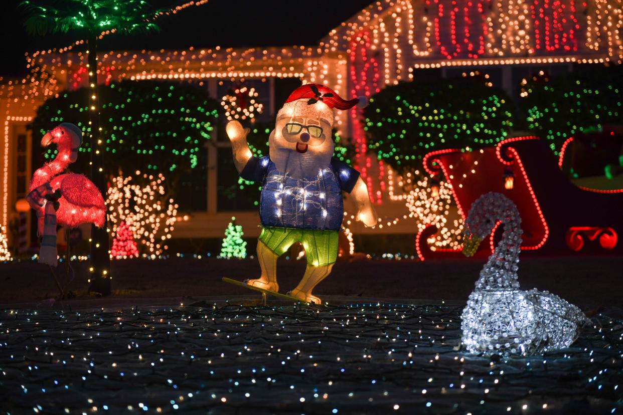 A light-up Santa in beach clothes stands in the yard at the Hair residence on Oxpens Road in Warrenville, S.C., on Monday, Dec. 11, 2023.