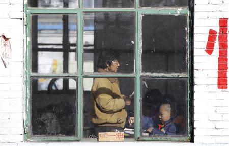 A teacher reads to students in class at Pengying School on the outskirts of Beijing November 11, 2013. REUTERS/Jason Lee