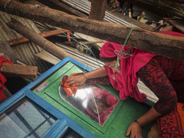 A woman salvages belongings from her home damaged by Cyclone Mocha at Saint Martin island in Cox's Bazar, Bangladesh, Monday, May 15, 2023. (AP Photo/Al-emrun Garjon)