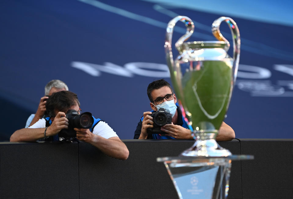 LISBON, PORTUGAL - AUGUST 23: Photographers are seen at work inside the stadium next to the Champions League Trophy prior to the UEFA Champions League Final match between Paris Saint-Germain and Bayern Munich at Estadio do Sport Lisboa e Benfica on August 23, 2020 in Lisbon, Portugal. (Photo by Michael Regan - UEFA/UEFA via Getty Images)