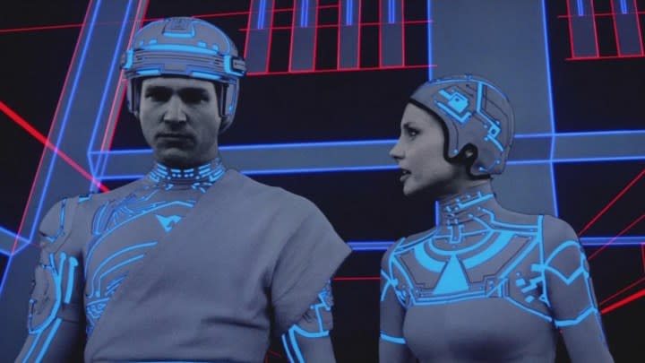 A VR woman looks at a VR man in 1982's Tron.