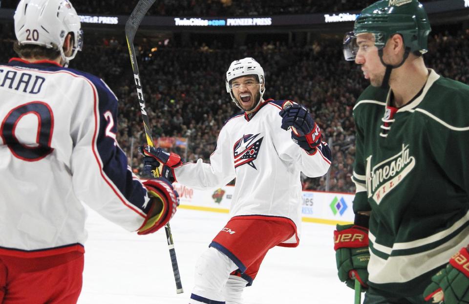 Columbus Blue Jackets left wing Brandon Saad (20) and defenseman Seth Jones (3) celebrate a goal as Minnesota Wild right wing Nino Niederreiter skates by during the second period of an NHL hockey game Saturday, Dec. 31, 2016, in St. Paul, Minn. (AP Photo/Andy Clayton-King)