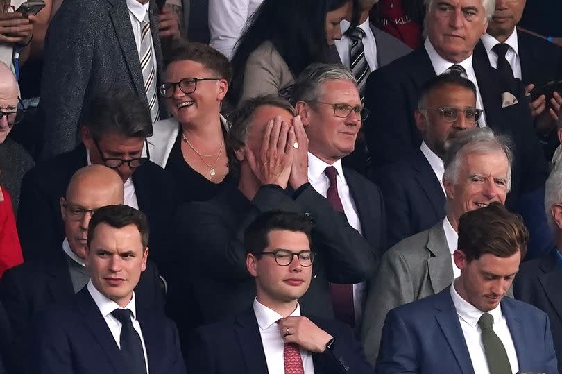 Sir Jim Ratcliffe holds his head in his hands in front of Sir Keir Starmer in the Old Trafford directors' box