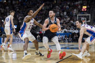 Samford guard Rylan Jones (21) drives while guarded by Kansas guard Elmarko Jackson (13) during the second half of a first-round college basketball game in the men'd NCAA Tournament in Salt Lake City, Thursday, March 21, 2024. (AP Photo/Isaac Hale)