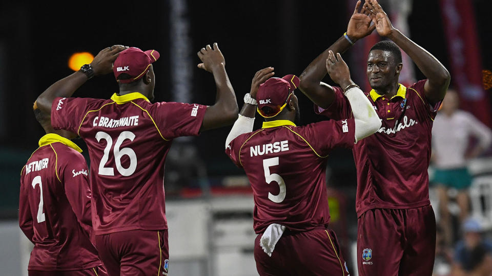 Jason Holder and his West Indies teammates celebrate. (Photo by RANDY BROOKS/AFP/Getty Images)