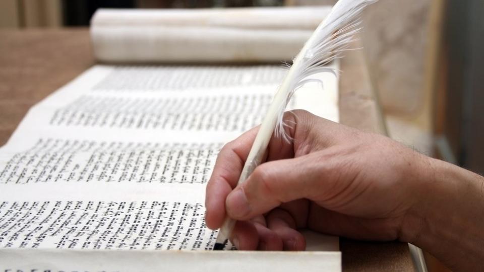 Una persona escribe en hebreo