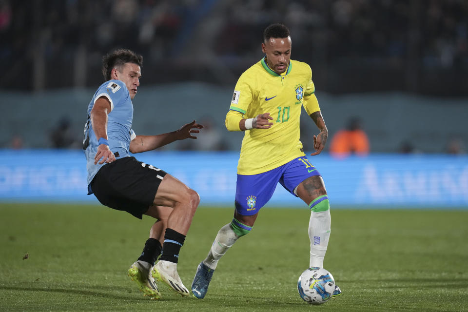 Brazil's Neymar, right, is challenged by Uruguay's Manuel Ugarte during a qualifying soccer match for the FIFA World Cup 2026 at Centenario stadium in Montevideo, Uruguay, Tuesday, Oct. 17, 2023. (AP Photo/Matilde Campodonico)