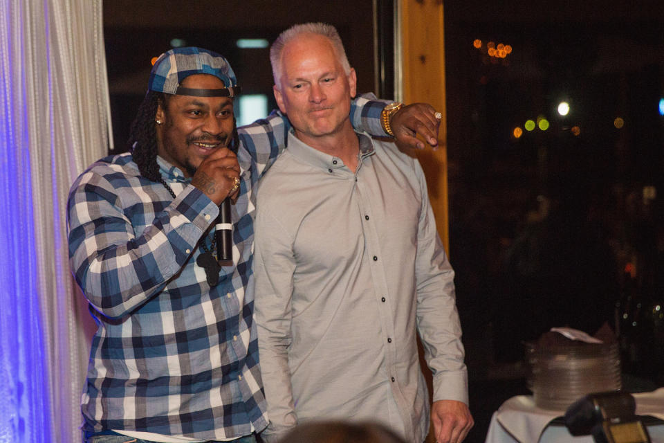 SEATTLE, WA - DECEMBER 14:  Marshawn Lynch (L) and Kenny Mayne speak during the FAM 1st FAMILY FOUNDATION Charity Event at The Edgewater Hotel on December 14, 2014 in Seattle, Washington.  (Photo by Mat Hayward/Getty Images for 1st Family Foundation)