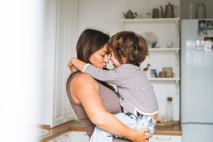 Mother embracing her young child in a home kitchen