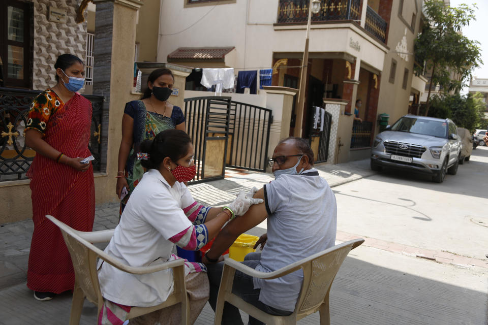 A health worker administers the COVISHIELD vaccine for COVID-19 at a residential area in Ahmedabad, India, Sunday, April 4, 2021. (AP Photo/Ajit Solanki)