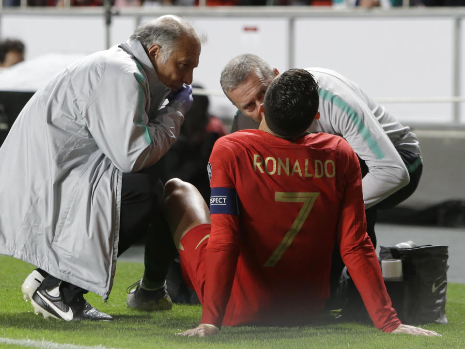 Portugal's Cristiano Ronaldo receives treatment from medical staff during the Euro 2020 group B qualifying soccer match between Portugal and Serbia at the Luz stadium in Lisbon, Portugal, Monday, March 25, 2019. (AP Photo/Armando Franca)