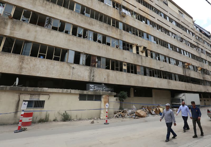 People walk past Sleep Comfort furniture factory that was damaged during Beirut port blast