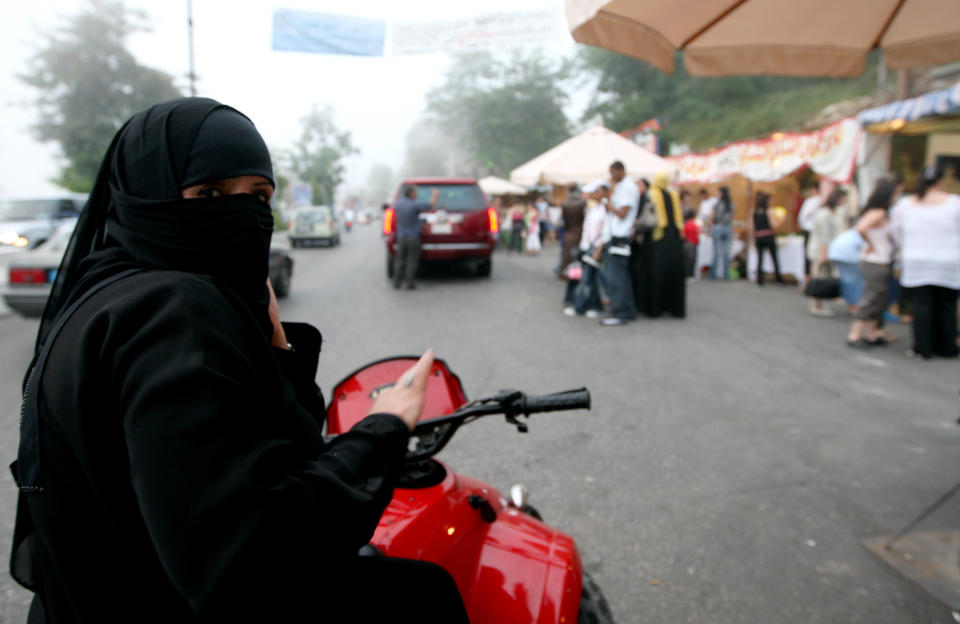 A ban on women riding bicycles and motorbikes is lifted. Females must be accompanied by a male guardian, usually a husband or son, and only ride in restricted areas.  <em>A veiled Saudi women rides a motorbike in the tourist town of Aley, east of Beirut on July 23, 2008. (JOSEPH BARRAK/AFP/Getty Images)</em>