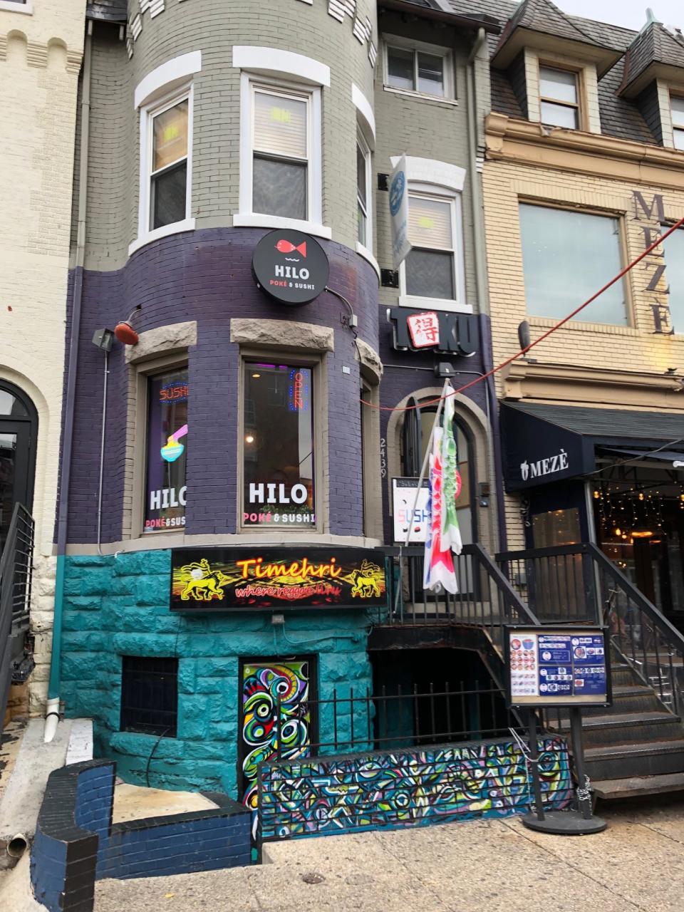 The entrance to Hilo Poke & Sushi in Washington DC, with a purple exterior and stairs leading to the front door