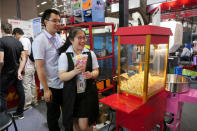 A visitor gets popcorn from a popcorn machine displayed at the China Import and Export Fair in Guangzhou, China April 17, 2017. REUTERS/Venus Wu