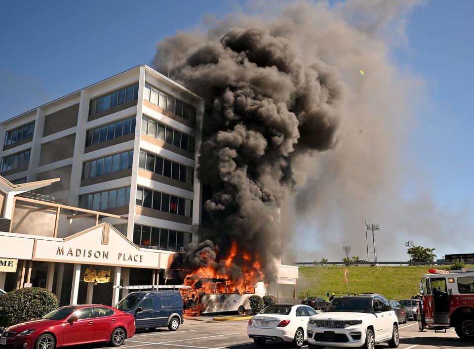 A NYC United Express passenger vehicle explodes into flames and thick, black smoke as firefighters arrive at Madison Place shopping center Saturday.