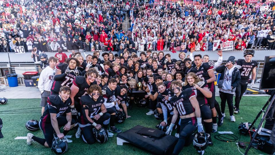 Badger players pose with their fans and the championship trophy after a 34-33 victory over Waunakee in the WIAA Division 2 state championship football game at Camp Randall Stadium in Madison on Friday, November 17, 2023.