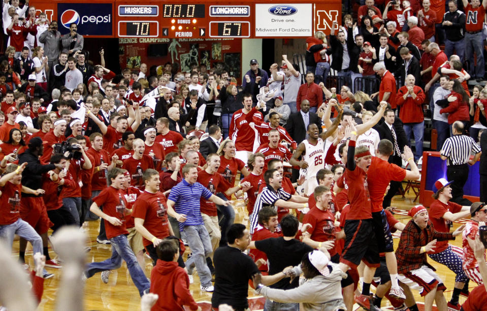 FILE - Nebraska fans storm the court after Nebraska beat No. 3 Texas 70-67 in an NCAA college basketball game, in Lincoln, Neb., Saturday, Feb. 19, 2011. Recent incidents in college basketball have underscored the potential dangers that come from jubilant fans storming the court after the game comes to an end. Finding a solution is proving to be a challenge. (AP Photo/Nati Harnik, File)