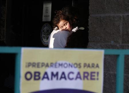 Julissa Esparza, 2, sleeps in the arms of her grandfather Leobardo Salazar, 58, as they wait in line at a health insurance enrollment event in Cudahy, California March 27, 2014. REUTERS/Lucy Nicholson