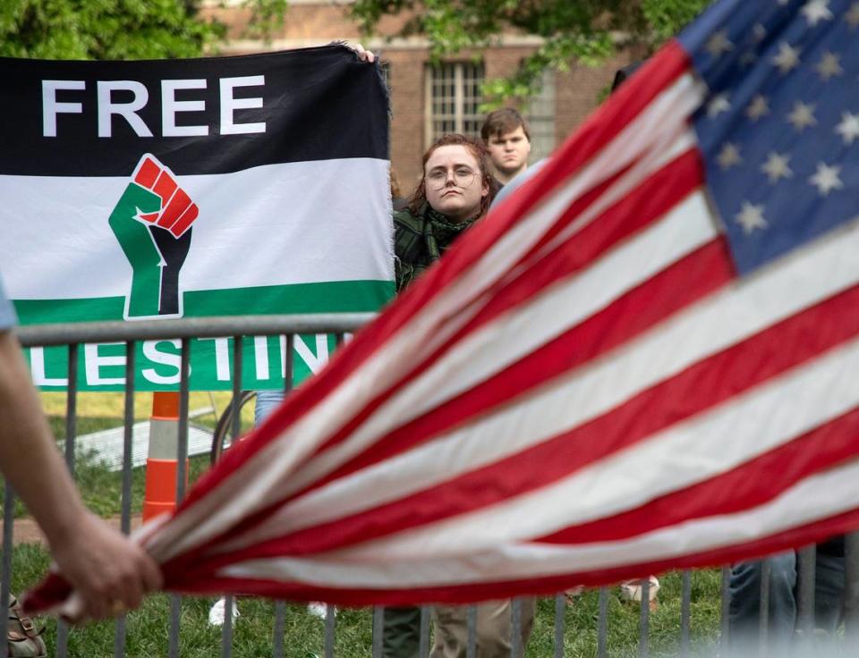 People gather near a fenced enclosure surrounding the flagpole on the quad at UNC-Chapel Hill on Tuesday, April 30, 2024. UNC-Chapel Hill police charged 36 members of a pro-Palestinian “Gaza solidarity encampment” Tuesday morning after warning the group to remove its tents from campus or face possible arrest, suspension or expulsion from the university. Earlier in the afternoon, protesters took an American flag down from the flagpole and then mounted a Palestinian flag in its place.