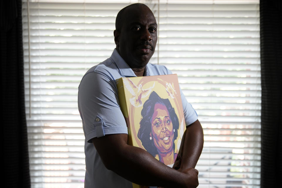 Malcolm Graham holds a painting of his late sister, Cynthia Graham-Hurd, on Wednesday, July 15, 2020, in Charlotte, N.C. Graham, a former state senator in North Carolina, firmly believes that America's failure to confront white supremacism cost the life of his older sister, Cynthia Graham-Hurd. She was among the nine killed by Dylann Roof in 2015 during a Bible study meeting at Mother Emanuel AME Church in Charleston, S.C. (AP Photo/Chris Carlson)