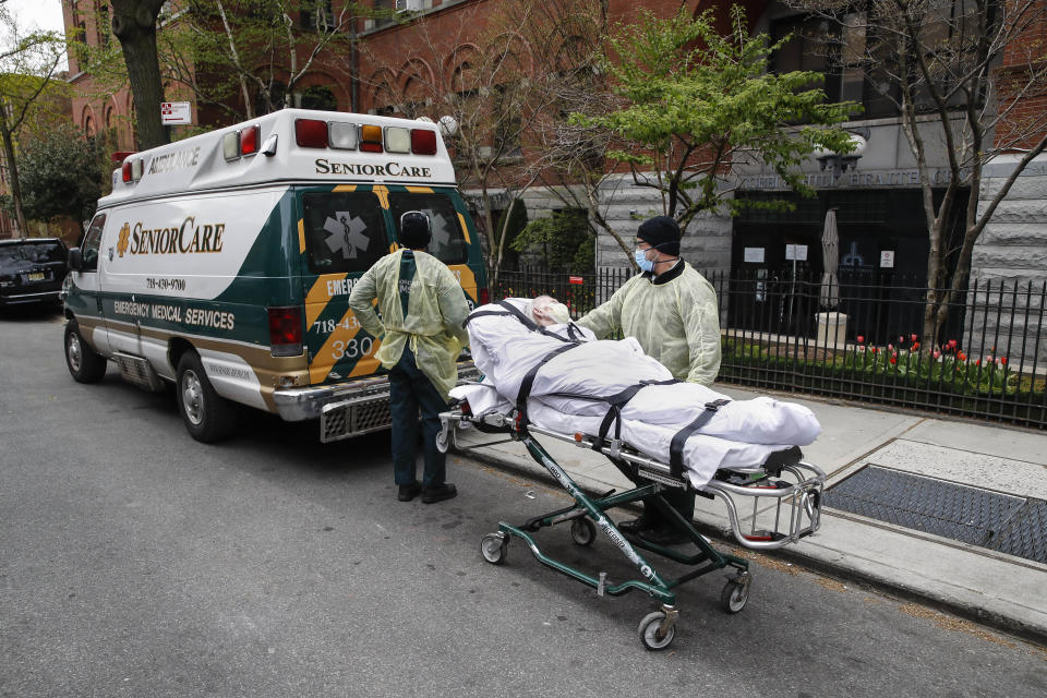 FILE- In this April 17, 2020 file photo, a patient is wheeled out of Cobble Hill Health Center by emergency medical workers in the Brooklyn borough of New York. On Thursday, April 23, New York Gov. Andrew Cuomo said that nursing homes in New York must immediately report how they've complied with regulations for resident care during the coronavirus, and non-compliant facilities could face hefty fines or lose their licenses (AP Photo/John Minchillo, File)